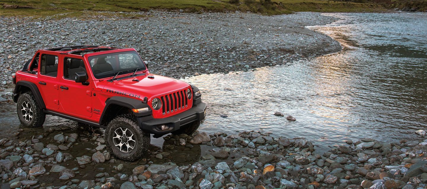 Jeep Wrangler Rubicon in Red parked at the river.
